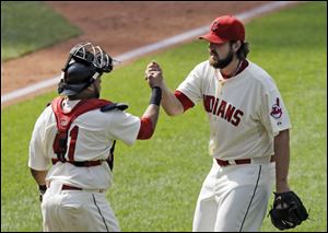 Indians catcher Carlos Santana, left, and closer Chris Perez celebrate after the final out in a 6-5 win against the Los Angeles Angels on Sunday in Cleveland.