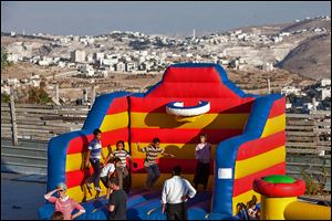 Israeli children play near a building site during an event to mark the resumption of housing construction in East Jerusalem Sunday. The action raised concerns among both Palestinians and Israelis, set to meet Wednesday for peace talks.