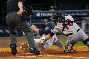 Toledo's Danny Worth slides safely into home plate ahead of the tag by Indianapolis catcher Lucas May in Saturday night’s game at Fifth Third Field. Worth had the game-winning hit. 