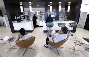 Customers sit in the cafe area of Hines Park Lincoln in Plymouth, Mich., the result of Ford Motor Co.'s dealer makeovers to appeal to younger, more discerning buyers for its Lincoln line of cars. Ford purged underperforming dealerships and is prodding the rest to make expensive updates.