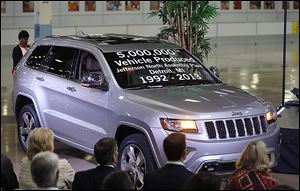 Chrysler Group employees watch as the automaker shows off a Jeep Grand Cherokee, the 5 millionth vehicle produced at the Jefferson North Assembly Plant.  The Tuesday event marked a milestone in the history of the auto plant, which has been operating in Detroit since 1992.