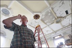 German native Hans Klinck, 65, of Findlay inspects the plaster repairs he made on the original ceiling in Courtroom 1 on the third floor of the Hancock County Courthouse.