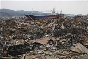 In this March, 2011 photo, a beached ship sits among the rubble in a residential neighborhood after the March 11 earthquake and tsunami in Kesennuma in Miyagi prefecture, northern Japan. The stranded fishing boat that became a symbol of the devastation of Japan's 2011 tsunami has long divided a northeastern coastal city.