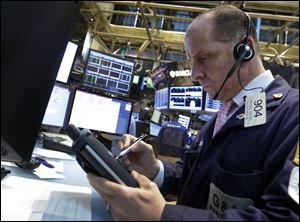 Trader Michael Urkonis works on the floor of the New York Stock Exchange. Hopes over the European economy coupled with a strong bounce-back in Japan's Nikkei stock index shored up markets Tuesday, ahead of key U.S. retail sales data that could have a bearing on when the Federal Reserve starts to rein in its monetary stimulus.