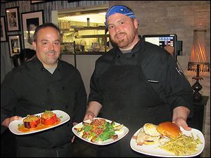 Mike Graber, a co-owner of Social, left, and executive chef  Jeff Dinnebeil show off specialties of the Perrysburg restaurant.