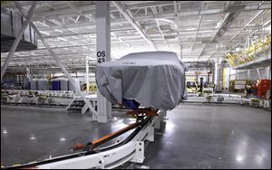 A covered vehicle sits in part of the new paint shop at Chrysler's Sterling Heights Assembly Plant in Sterling Heights, Mich. in July.