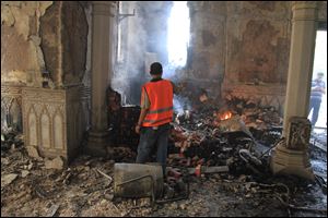 An Egyptian takes video of the burning remains of the Rabaah al-Adawiya mosque, in the center of the largest protest  camp of supporters of ousted President Mohammed Morsi, that was cleared by security forces, in the district of Nasr city, Cairo, Egypt.