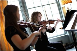 Toledo School for the Arts student Arianna Dyer of Ottawa Hills, right, plays the violin along with student Olivia Bryan of Sylvania.