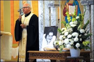 The Rev. George Shalhoub offers a blessing during a memorial service for pioneering journalist Helen Thomas at St. George Antiochian Orthodox Church in Troy, Mich. Mrs. Thomas, 92, died last month in Washington.