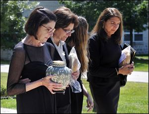 Terri DeLeon, a niece of Helen Thomas, carries the urn with the ashes of Mrs.Thomas along with family members after a memorial service for the pioneering journalist at St. George Antiochian Orthodox Church in Troy, Mich.