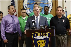 D. Michael Collins, independent candidate for Toledo mayor, center, is endorsed by  Dan Wagner, president of the Toledo Police Patrolman's Association, left, and Capt. Jeffrey A. Romstadt, president of Toledo Firefighters Local 92,  right, during a news conference at the Toledo Police Patrolman's Union Hall.