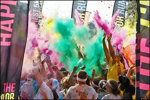 Participants in the Color Run celebrate during the after-run ‘Finish Festival’ Saturday in Promenade Park in downtown Toledo. The untimed race is billed as  the ‘Happiest 5K on the Planet.’