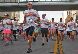 Runners head up Summit Street from Promenade Park during the Color Run on Saturday on the streets of downtown Toledo. 