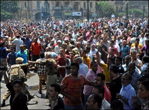 A member of Egyptian security forces, at left, tries to keep crowds away from the al-Fatah mosque, in Ramses Square, downtown Cairo.