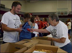Toby Sass of the Francis Family YMCA and Leo's Leaders, left, receives crayons from RSVP volunteer Jean Brown of Lambertville during a school supply drive in Monroe County.