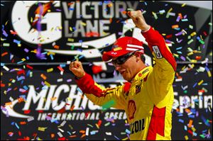 Joey Logano celebrates his NASCAR Sprint Cup Series win in the Pure Michigan 400 at Michigan International Speedway.