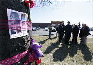 Pictures of Kaitlin Gerger hang on a tree at Southland Shopping Center. Ms. Gerber was chased in her car and shot in a South Toledo parking lot by her on-again, off-again boyfriend, Jashua Perz, 29, who subsequently killed himself during a standoff with police. 