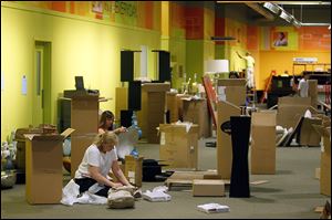 Workers unpack items in the clearance center of the new Art Van furniture store that opens Aug. 31. It will em­ploy 100 people.