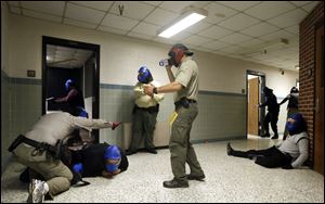 FBI instructor Mike Sotka, center, films local police officers as they participate in an active shooter drill in a college classroom building in Salisbury, Md., as part of an FBI program on Aug. 13.