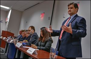 Joe McNamara, right, attends a mayoral candidate forum at The United Way of Greater Toledo with Mayor Mike Bell, D. Michael Collins, Opal Covey, Alan Cox, Michael Konwinski, and Anita Lopez. 