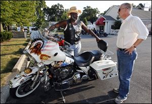 Mayor Mike Bell shows shows his motorcycle to Blade associate editor Keith Burris outside El Camino in West Toledo.