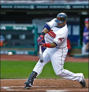 The Indians' Carlos Santana hits an RBI-single off the Twins' Samuel Deduno in the first inning to score Michael Bourn.