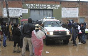 Inmates relatives and members of the press surround an ambulance leaving the Palmasola jail today in Santa Cruz, Bolivia.