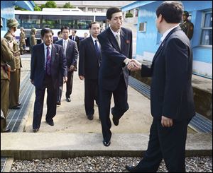 Head of the North Korean working-level delegation Park Yong Il shakes hand his South Korean counterpart Lee Duk-haeng, right, as he crosses border line to hold their meeting at the Peace House of south side of the border village of Panmunjom, which has separated the two Koreas since the Korean War, in Paju, South Korea.