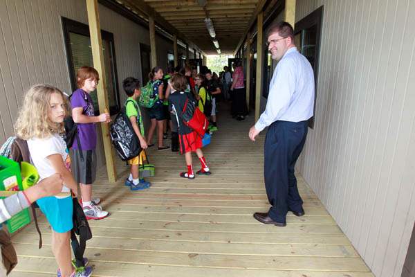 Scott-Best-principal-right-greets-fifth-grade-students-as-they-head-into-class