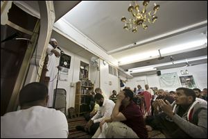 Dr. Muhamad Albar, far left, speaks to a congregation during Jumu'ah prayer service at the Islamic Society of Bay Ridge mosque on Friday in the Brooklyn borough of New York.