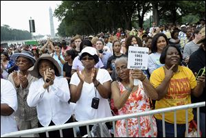 Three women who attended previous Marches on Washington, from left, Armanda Hawkins of Memphis, Vera Moore of Washington, and Betty Waller Gray of Richmond, Va., with sign, listen to speakers.