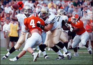 University of Central Florida quarterback Daunte Culpepper throws the ball under pressure from Bowling Green's D.J. Durkin (44) in 1998. 