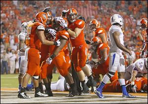 Bowling Green's William Houston, center, is congratulated by teammates after scoring a touchdown in the fourth quarter against Tulsa at Doyt Perry Stadium in Bowling Green. The Falcons blew open the close game in the second half.
