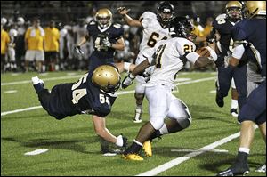 St. John's Jesuit senior Geno DeMarco misses the tackle as Cleveland Heights player Marcus Bagley runs toward a 275-yard game on 29 carries, including touchdown runs of 2, 1, 8, and 5 yards.