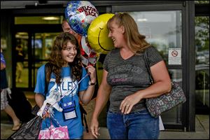 Bakhtiniso Kamaloua, 15, an exchange student from Tajikistan, and her host, Yulinda Cousino of Gibsonburg, can’t conceal happiness after Bakhtiniso’s arrival at Toledo Express Airport on Aug. 22. Bakhtiniso started classes Monday at Gibsonburg High and has joined the cross country team. 