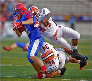 St. Francis' Andrew Bonfiglio is tackled by Southview players Myles Magnus (34) and Kim Jackson (44) during the second quarter.