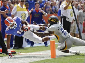 Florida's Valdez Showers (10) is pushed out-of-bounds by Toledo cornerback Chris Dukes (5) short of the goal line after pass reception.