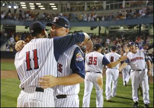 Toledo Mud Hens manager Phil Nevin gets a hug from player Argenis Diaz (11) after the Hens defeat the Columbus Clippers at Fifth Third Field, Saturday, August 31, 2013.