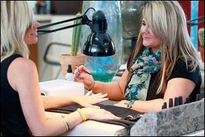 Nail stylist Cortnee Minkowski, right, creates nail art on Amanda Wrozek’s nails at Future Wave in Oregon.
