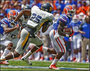 Florida's Mack Brown runs past Toledo's Chaz Whittaker. Brown filled in for starter Matt Jones and finished with 112 yards rushing.