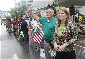 Toledo Councilman D. Michael Collins, who is running for mayor, watches the parade with Elizabeth Shuler, AFL-CIO secretary-treasurer, from the grandstand.