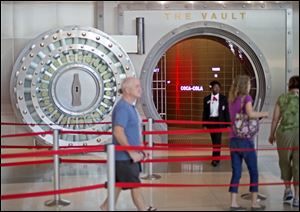 Tourists pass the vault exhibit containing the secret recipe for Coca-Cola at the World of Coca-Cola museum in Atlanta. The 127-year-old recipe for Coke sits inside a steel vault thats bathed in red security lights, while security cameras monitor the area to ensure the formula stays a secret.