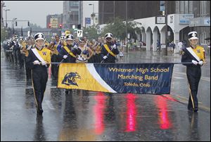 The Whitmer High School band marches through the rain near the front of the annual Labor Day parade in downtown Toledo.