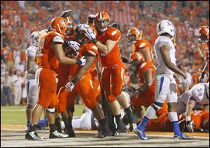 BGSU's William Houston (32) is mobbed by teammates after scoring a touchdown in the fourth quarter against the University of Tulsa Thursday.