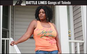 Cleo Wallace stands on her porch at her home in Toledo. Wallace is moving sometime in the first week of September to a place near Atlanta, in hopes of giving her children a better life.