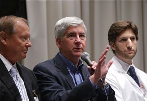 Gov. Rick Snyder, center, is expected to sign the measure which adds low-income residents to Medicaid coverage in Michigan. 