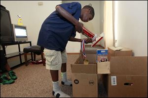 Jamonte Wallace, 11 packs his sports trophies as the family finishes packing for their move to a place near Atlanta. Wallace is moving sometime in the first week of September in hopes of giving her children a better life.