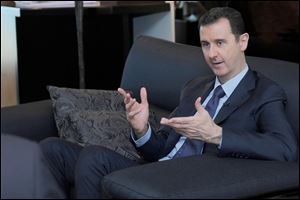 Syrian President Bashar Assad gestures as he speaks during an interview with a Russian newspaper, in Damascus, Syria, last month.