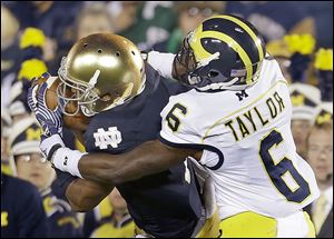 Notre Dame's TJ Jones makes a catch against Michigan's Raymon Taylor last season. Next year’s contest could be the last for a while.