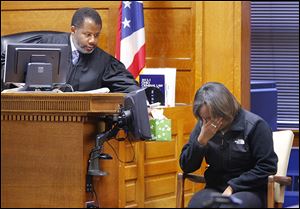 Judge Myron Duhart offers tissues to Keisha Boykin, 18, as she breaks down while testifying in the trial of Robert F. Carter. Carter is accused of killing her mother, Wendabi Triplett, 41.